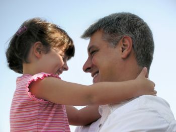 Happy father and daughter share a smile and a hug